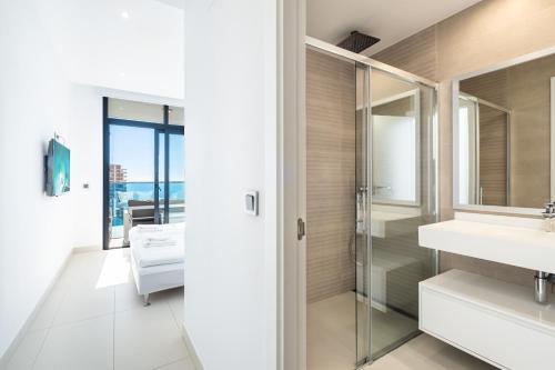 een badkamer met een glazen douche en een wastafel bij Sunset Drive Resort Apartment 4-8 Poniente Beach in Benidorm