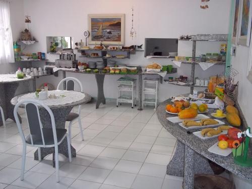 uma cozinha com duas mesas com fruta em Hotel Pousada Reimar em Balneário Camboriú