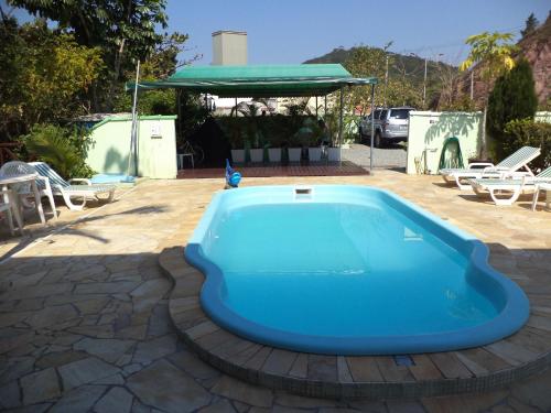 uma piscina azul num pátio com um gazebo em Hotel Pousada Reimar em Balneário Camboriú