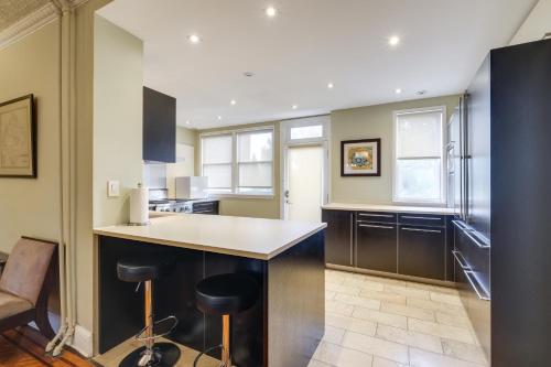 a kitchen with a counter and stools in it at 2 Mi to National Mall Modern DC Home in Washington, D.C.