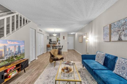 a living room with a blue couch and a tv at Cozy Townhouse - Gym Pool Golf Fast WiFi 2B2B in Tampa