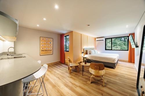 Habitación de hotel con cama y cocina en The Somos Flats Central Poblado en Medellín