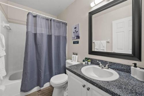 uma casa de banho com um lavatório, um WC e um espelho. em Cozy Townhouse - Gym Pool Golf Fast WiFi 2B2B em Tampa