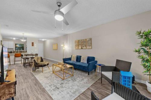 a living room with a blue couch and chairs at Cozy Townhouse - Gym Pool Golf Fast WiFi 2B2B in Tampa