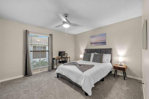 um quarto branco com uma cama e uma janela em Cozy Townhouse - Gym Pool Golf Fast WiFi 2B2B em Tampa