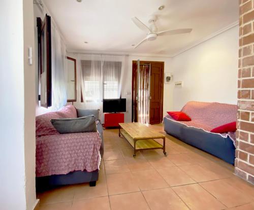 un soggiorno con divano e tavolo di Beach House close to Alicante and Airport - Apartamento Completo a Santa Pola