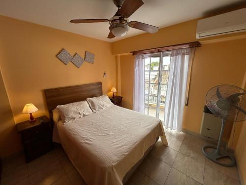 1 dormitorio con 1 cama con ventilador y ventana en Complejo Berilde I en San Clemente del Tuyú
