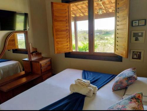 una camera da letto con due letti e una finestra di Casa Candeia a Diamantina