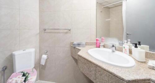 Greatest location Dubai في دبي: حمام مع حوض ومرحاض ومرآة