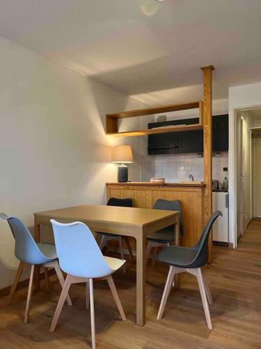 une salle à manger avec une table et des chaises et une cuisine dans l'établissement La Foux d Allos Haut - Studio avec coin montagne 4 pers refait à neuf - Plein sud - Internet Fibre, à La Foux