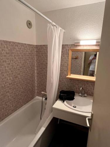 une salle de bain avec un lavabo, une baignoire et un miroir dans l'établissement La Foux d Allos Haut - Studio avec coin montagne 4 pers refait à neuf - Plein sud - Internet Fibre, à La Foux