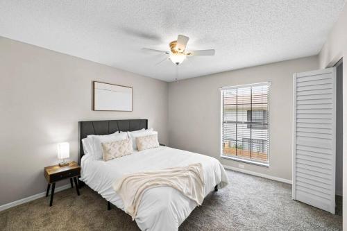 タンパにあるCozy Townhouse - Gym Pool Golf Fast WiFi 2B2Bのベッドと天井扇風機のある寝室