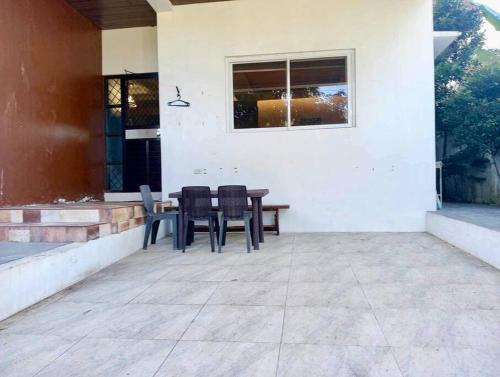 a patio with chairs and a table and a window at Vacation homes metrogate estate in Silang