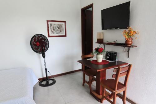 Zimmer mit einem Schreibtisch, einem Ventilator und einem Bett. in der Unterkunft Casa Flora in Cabo Frio