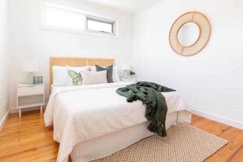 a bedroom with a large white bed with a rug at Elwood Star- Beachside Retreat in Melbourne