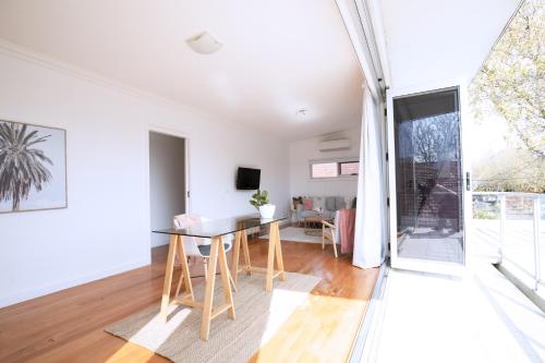 a dining room and living room with a table and chairs at Elwood Star- Beachside Retreat in Melbourne