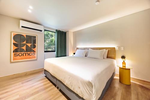 a bedroom with a large bed and a window at The Somos Central Hotel Poblado in Medellín