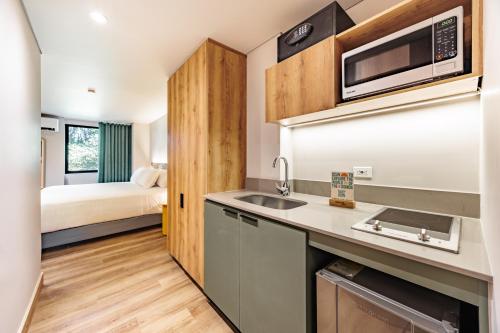 a kitchen with a sink and a bed in a room at The Somos Central Hotel Poblado in Medellín