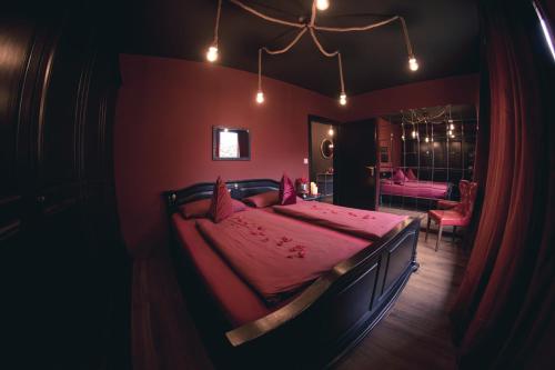 1 dormitorio con 1 cama grande con sábanas rosas en Erwachsenenhotel BDSM Apartment Hotel Emotion Apartments mit privater Sauna & Whirlpool en Vlotho