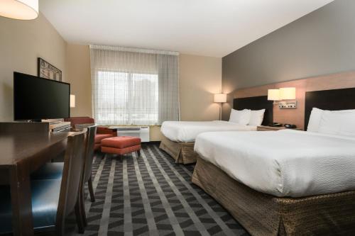 a hotel room with two beds and a flat screen tv at TownePlace Suites by Marriott Houston Galleria Area in Houston