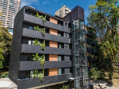 un edificio de apartamentos con plantas en la fachada en The Somos Flats Central Poblado en Medellín