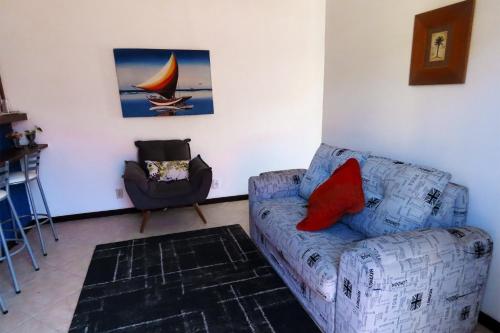 a living room with a couch and a chair at Casa Flora in Cabo Frio
