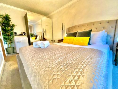 1 dormitorio con 1 cama grande con almohadas amarillas y azules en Simply relax en Londres