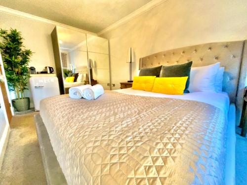 a bedroom with a large bed with yellow and blue pillows at Simply relax in London