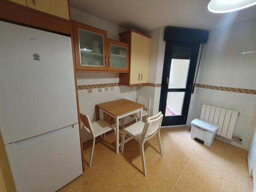 uma pequena cozinha com uma mesa e um frigorífico em Casa Aguiar em Zamora