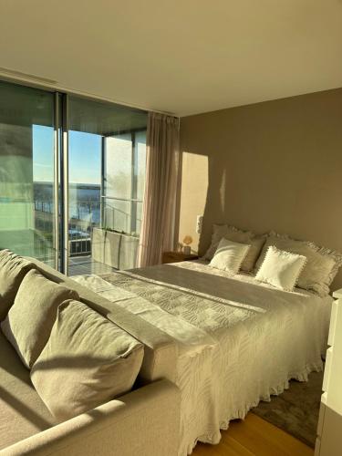 una camera da letto con un grande letto con una grande finestra di Douro Corner a Vila Nova de Gaia