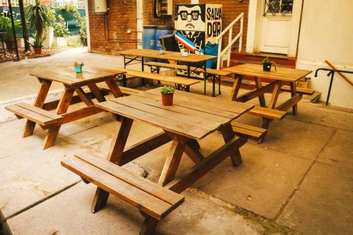 a group of wooden picnic tables in a patio at Hostal Salvador in Santiago