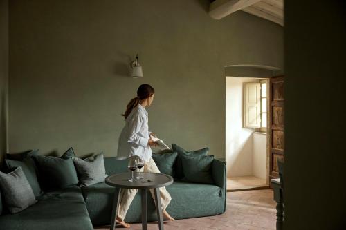 a woman sitting on a couch in a living room at Castello Del Nero - Podere San Filippo in Tavarnelle in Val di Pesa