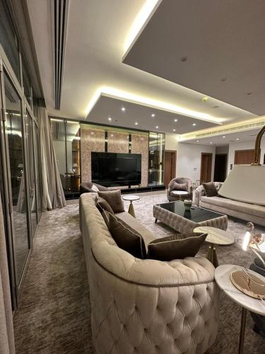 uma sala de estar com um sofá grande e uma televisão em شقة فاخرة في برج جلامور em Riyadh