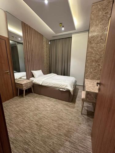 um quarto de hotel com uma cama e um espelho em شقة فاخرة في برج جلامور em Riyadh