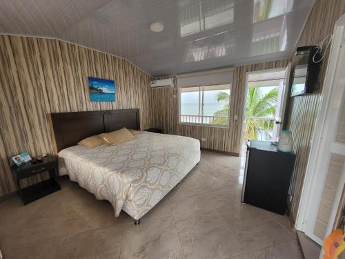 a bedroom with a large bed and a large window at HOTEL POSADA DEL MAR in Providencia