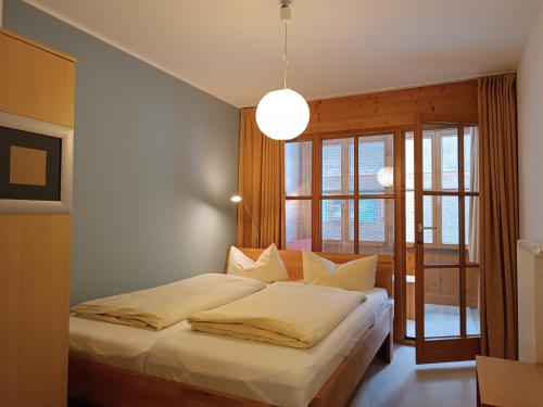 - une chambre avec un lit et une grande fenêtre dans l'établissement Wikasa, à Ofterschwang