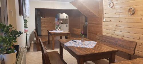 a dining room with two tables and a kitchen at Pokoje u Juroszka in Istebna