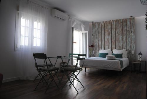 コニル・デ・ラ・フロンテーラにあるConil apartamentos la Dama y el Vagabundoのベッドルーム1室(ベッド1台、テーブル、椅子付)