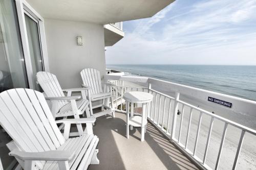 three chairs on a balcony overlooking the ocean at 0512 Waters Edge Resort condo in Myrtle Beach