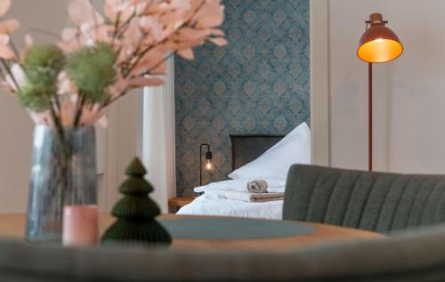 a bedroom with a bed and a table with a vase of flowers at Seepanorama Apartments am Grundlsee - Your Austrian Home in Grundlsee