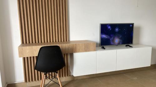 Habitación con escritorio, TV y silla. en Dpto comodo, luminoso y con una hermosa vista de Salta en Salta