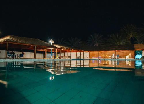 una piscina por la noche con un edificio en Jnayna Space, en Degache