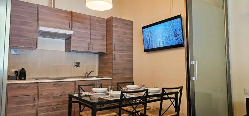 a kitchen with a table with chairs and a television at A bordo pista - Val di Luce in Abetone