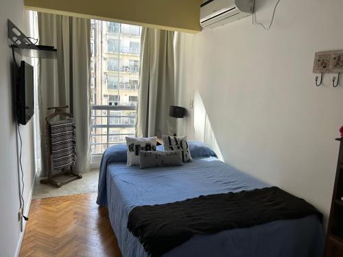 a bedroom with a bed and a large window at Excelente piso muy luminoso en Palermo in Buenos Aires