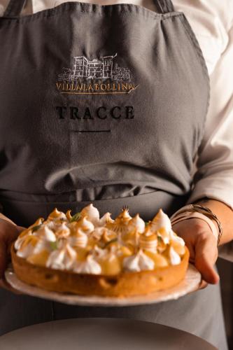 a person holding a plate with a pastry on it at Hotel Villa La Bollina in Serravalle Scrivia