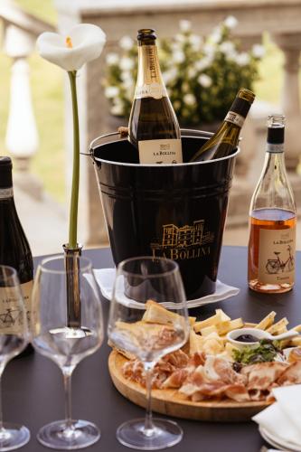 a table with two bottles of wine and wine glasses at Hotel Villa La Bollina in Serravalle Scrivia