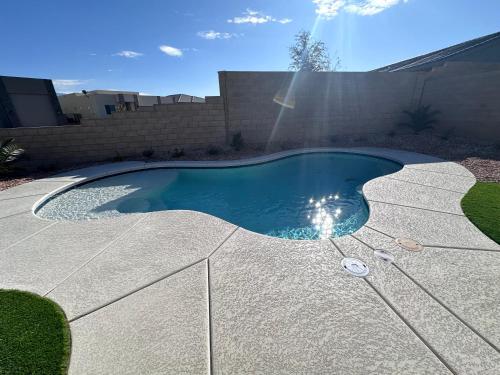 a swimming pool in a backyard with the sun shining at 4BR Oasis - Pool and Spa - Near Golf and Casinos in Mesquite