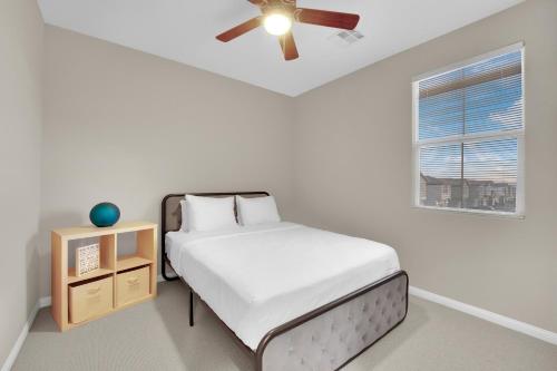 a white bedroom with a bed and a ceiling fan at Todor Las Vegas Home Away From Home in Las Vegas