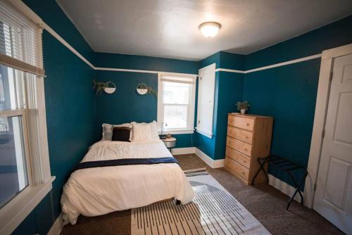 Dormitorio azul con cama y ventana en Cozy Comfort Minutes From Downtown Klamath Falls, en Klamath Falls