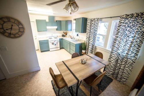 a kitchen with a wooden table and chairs and a clock at Cozy Comfort Minutes From Downtown Klamath Falls in Klamath Falls